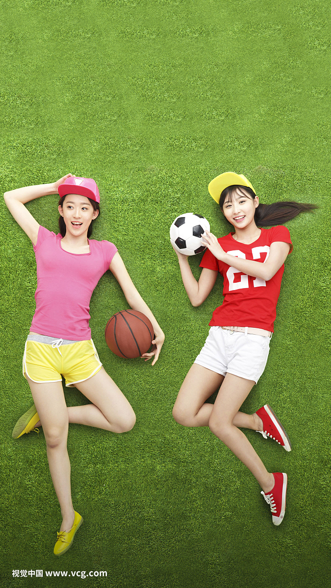 青年女人拿着球躺在草地上