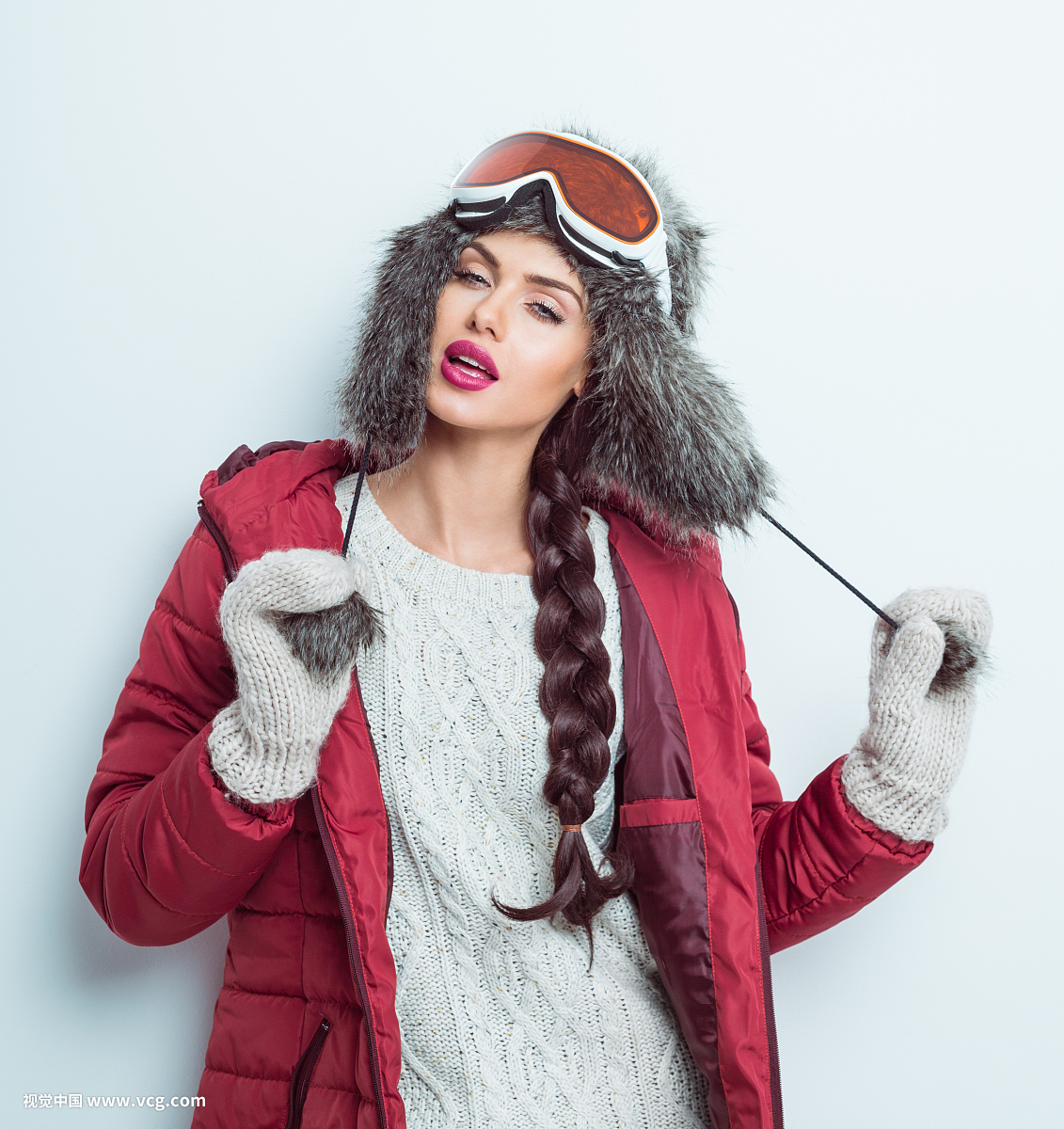 Sensual woman in winter outfit - puffer jacket, fur hat