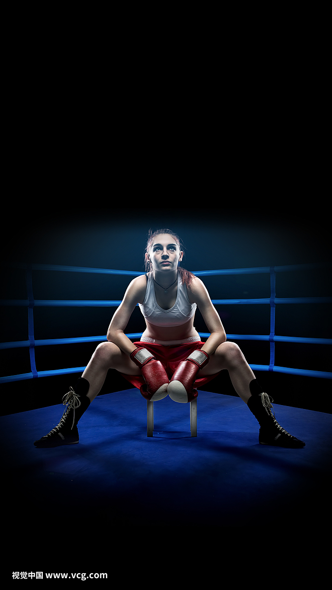 Boxing woman sitting alone in the boxing arena , surrounded by blue lights