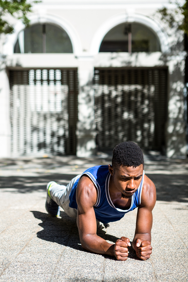 A muscular man on plank position on a sunny day