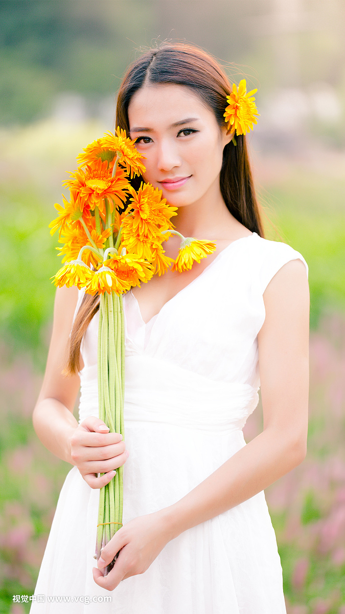 年轻美丽的中国女孩在花园里玩