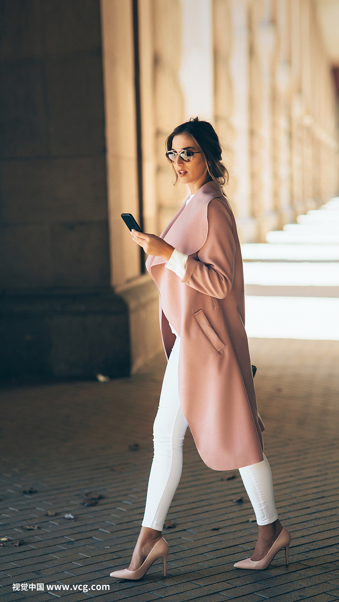 Beautiful elegant woman texting outdoors