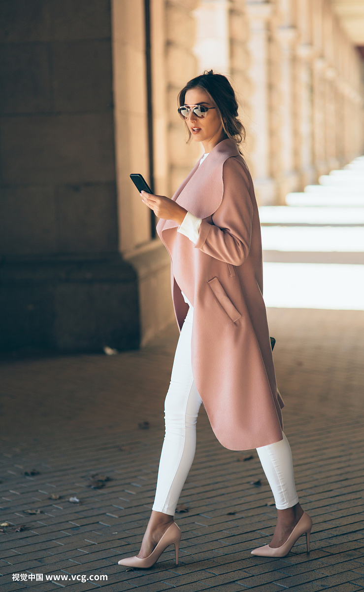 Beautiful elegant woman texting outdoors